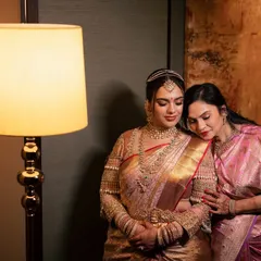 A bride and her mother share a quiet, emotional moment before the wedding ceremony, their bond captured under warm, soft light.