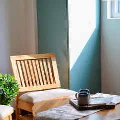 The seating area in the study room, featuring classic wooden chairs. The natural wood and simple design complement the rich wooden flooring and add to the warm, sun-lit feel of the space.