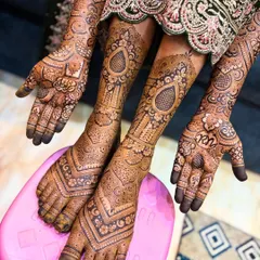 Another angle showing the full bridal mehendi. The bride's hands are placed over her feet, highlighting the beautiful continuity of the design.