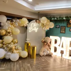 Here is the complete 'Oh Baby' shower setup with the marquee letters included. The combination of the balloon arch, neon sign, teddy bear, and illuminated letters makes for a full and festive display.