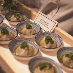 A comforting bowl of Darjeeling-style Pork Jhol Momos. The delicate dumplings are served in a light, flavorful broth and topped with a cilantro-garlic dip for a perfect bite.