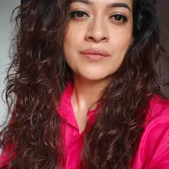 Even a simple look can be elevated with a pop of color. Here, the focus is on clean skin and a neutral lip, allowing the bright pink shirt to stand out.