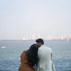 A quiet moment for Riyaz and Samreen, looking out at the Mumbai skyline from the water's edge. A classic and romantic city-meets-sea portrait.