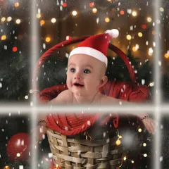 A baby's first Christmas magic. This little one, wearing a Santa hat, looks up in wonder at the falling snow from inside a festive basket, creating a magical holiday portrait.