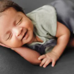 A repeat of the smiling newborn, a perfect example of a precious moment captured with skill.