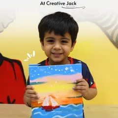 A young boy proudly holds up his colorful painting of a sailboat on the sea, a great example of the evolution of kids' art at my studio.