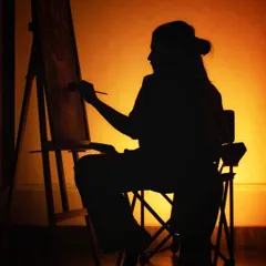 A silhouette of an artist at the easel, lost in their work. This photo captures the quiet, focused moments of the creative process, where it's just me, the canvas, and the paint.