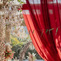 A close-up of the rich textures in our Sabyasachi-inspired decor. The deep red drapes provided a dramatic contrast to the intricate floral and pampas grass arrangements.