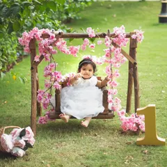 A sweet and calm moment on the swing. Outdoor sessions allow for a variety of moods and expressions, from playful laughter to quiet curiosity.