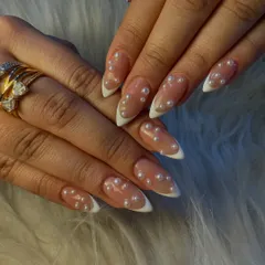 A timeless and sophisticated design. This set features a classic white French tip on a sharp stiletto nail, with the modern addition of delicate pearls scattered across the nail bed for a touch of elegance.