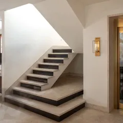 Staircases are often overlooked but are one of the most used parts of a home. This minimalist staircase is a design detail in itself, with its clean lines and the contrast between the light stone steps and dark risers.