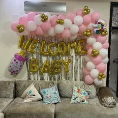 A wider shot of the welcome baby balloon arch. This view shows how the decoration fits perfectly above a standard sofa, making it an ideal choice for apartment living rooms.