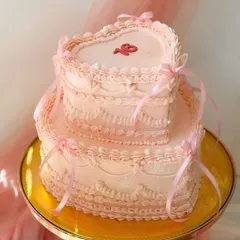 A spectacular two-tier heart-shaped cake with vintage Lambeth piping. This romantic design in soft pink is perfect for a sweet sixteen or a special anniversary.