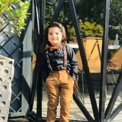 Styling for kids is about capturing their personality. For this magazine editorial, I created a dapper yet playful look with a classic black shirt, brown corduroy trousers, and fun Mickey Mouse suspenders to add a touch of whimsy.