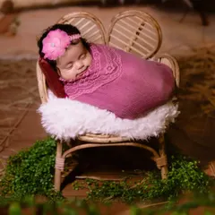 A peaceful newborn portrait. I use soft wraps and a tiny, cozy chair to create a safe and adorable setting for capturing your baby's first professional photos.