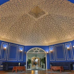 A wider view of the Mughal-inspired ceiling wallpaper, showing how it covers the expansive, curved ceiling to create a truly immersive and grand entrance for the hotel.
