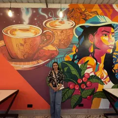 Here I am with the completed coffee-themed mural. It was a huge project, and I'm so proud of how my team and I brought this design to life.