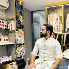 A candid moment in my men's couture section. I am surrounded by fabric swatches and designer pieces, always ready to help you find or create the perfect outfit for your occasion.
