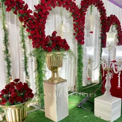 A classic and opulent Valima stage in red and gold. The decor features dramatic red rose arches, elegant candelabras, and gold vases, creating a timeless and regal setting for the couple.