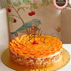 A beautiful and delicious Fresh Alphonso Mango Cake, a popular choice for Mother's Day. The top is decorated with an intricate rosette of fresh mango slices.