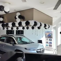 A wide view of our decoration for a NEXA showroom event in Navi Mumbai. The balloon garlands follow the architectural lines of the space, enhancing the showroom's modern look without obstructing the view of the cars.