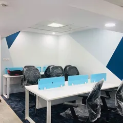 The actual completed office space, photographed during setup. This image shows how the final built environment faithfully matches the 3D render, from the wall paint design to the workstation layout.