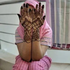 A beautiful and modest pose showcasing a full henna design for an engagement ceremony. The pattern features a traditional grid design that is always a classic choice.