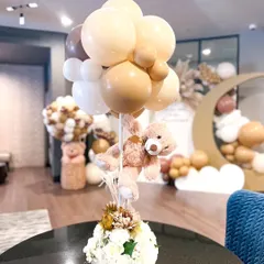 A whimsical centerpiece combining a teddy bear with a balloon bouquet. This is a perfect example of how I carry the party's theme through to the smallest details on every table.