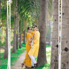 A cool and casual couple portrait during their Haldi event. The sunglasses add a fun, modern twist to their traditional yellow outfits.
