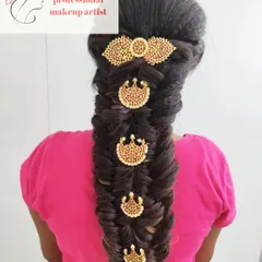 A traditional South Indian bridal braid. This fishtail braid is decorated with classic temple-style jadanagam jewelry for a timeless and elegant look.