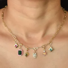 A custom charm necklace featuring a mix of colourful gems, a golden owl, and a heart charm. Each piece is chosen by you to create a unique story.