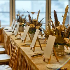 An elegant setup ready for guests to arrive. We arrange each station with a mini easel, a blank canvas, and brushes, all set against beautiful decor. Our paint party setups can be customized to match the theme and style of your event.