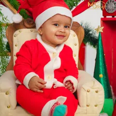The perfect little Santa. This Christmas-themed shoot features a baby in a Santa suit, sitting in a miniature armchair. It's a festive way to celebrate their first Christmas.