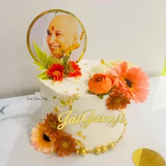Crafted with care and adorned with blessings. Another beautiful "Jai Guruji" cake, this time in white with orange flowers and gold leaf.
