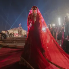 A moment of anticipation before the union. The bride's walk to the stage, veiled in red, is a timeless tradition I love to frame with dramatic lighting and a clear path, focusing all attention on her graceful approach.