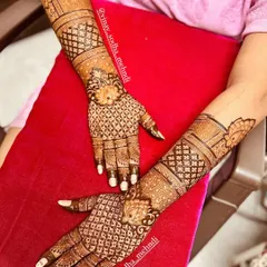 A beautiful bridal back-of-hand design with intricate check patterns and floral motifs. The symmetry and clean lines create a very elegant look.