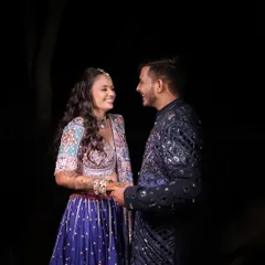 A candid moment of joy during a Dandiya night. The makeup is designed to look radiant and flawless even in low light, with a focus on glowing skin and defined eyes that sparkle as you celebrate.