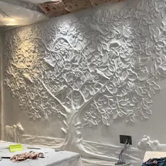 The raw, unpainted fiber sculpture of the Tree of Life, installed on the wall. This shows the foundational form before the artistic painting process begins.