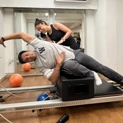 Congratulations to our newest instructor graduates. Here, a trainer-in-training gets hands-on experience correcting form on the reformer.