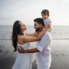 There's nothing like the joy of a growing family. This candid moment on the beach, with a happy toddler on his dad's shoulders, perfectly captures the love and excitement before a new arrival.