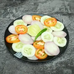 A simple plate of fresh green salad with cucumber, tomato, and onion. It's a healthy and refreshing accompaniment to any meal.