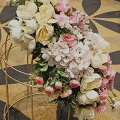 The small details make a big impact. This close-up shows a beautiful floral arrangement of pink and white peonies and hydrangeas, part of a larger decor scheme for an elegant corporate event.