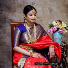 A vintage-inspired photoshoot. The rich red saree, traditional jewelry, and classic makeup create a look that feels like a timeless painting.