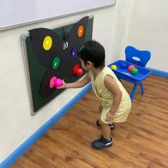 Leaning in for a closer look, this child is fully engaged with the butterfly activity. We create a learning environment that encourages curiosity and active participation.