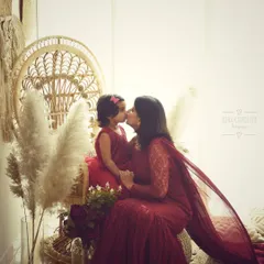 A kiss between mother and daughter. This silhouette-style shot is artistic and full of emotion, beautifully capturing a tender moment in a boho-chic setting.