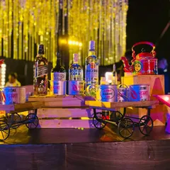 For a full Bollywood dhamaka, I bring the fun with quirky, custom props. This setup features hand-painted kettles and miniature carts displaying premium spirits, adding a playful and filmy touch to your cocktail party.