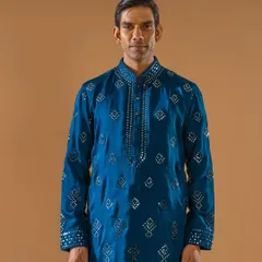 Grace in every stitch, reflection in every mirror. This teal kurta, embellished with a diamond-patterned mirror work, is a celebration of heritage craftsmanship and understated luxury.