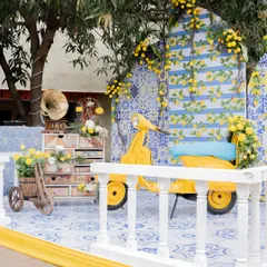 A closer look at our Mediterranean Haldi setup, featuring a vintage scooter, blue-tiled floors, and lemon-themed decor for a fresh, summery vibe.