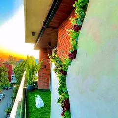 This South Delhi balcony now boasts a stunning sunset view over its new green landscape. The installation includes artificial grass and a custom-built planter with a mix of real and artificial plants for a vibrant look.