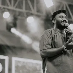 A black and white candid shot of me speaking to the audience while judging the dance competition at Soundarya Institute.